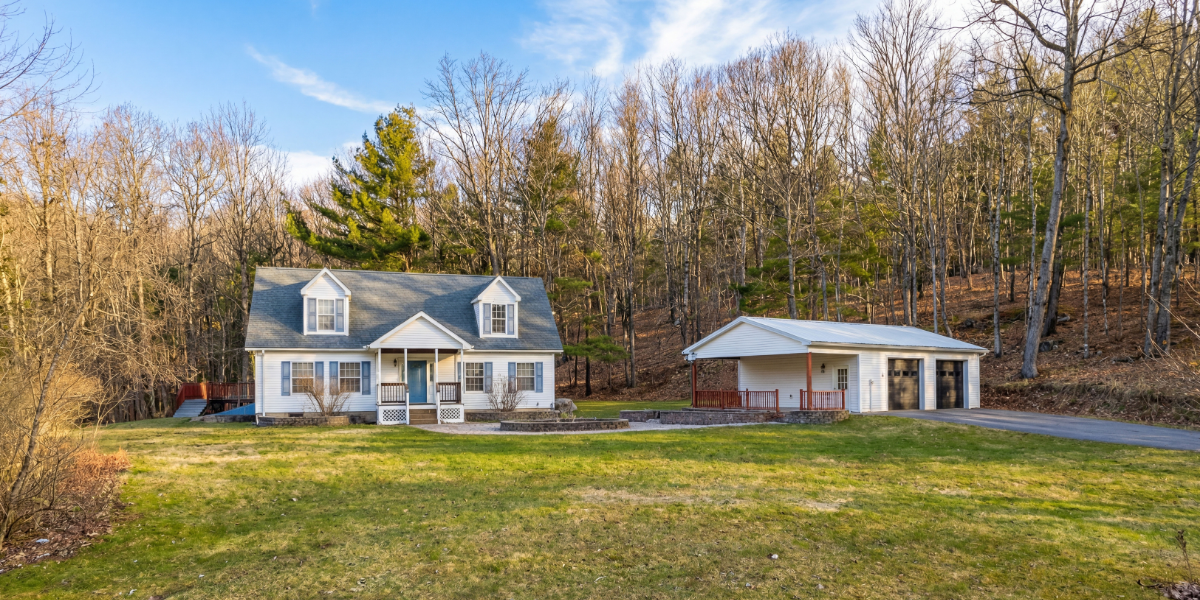 Classic white clapboard farmhouse on rolling pasture with stone walls near Cooperstown
