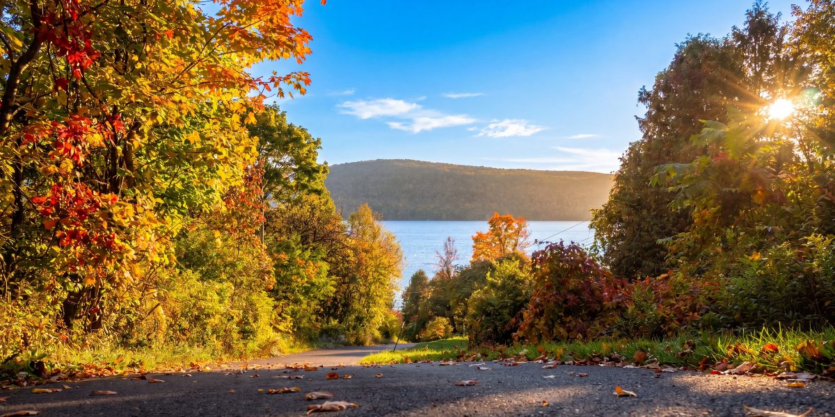 Otsego Lake in early autumn from the public dock with forested hillsides in orange and gold