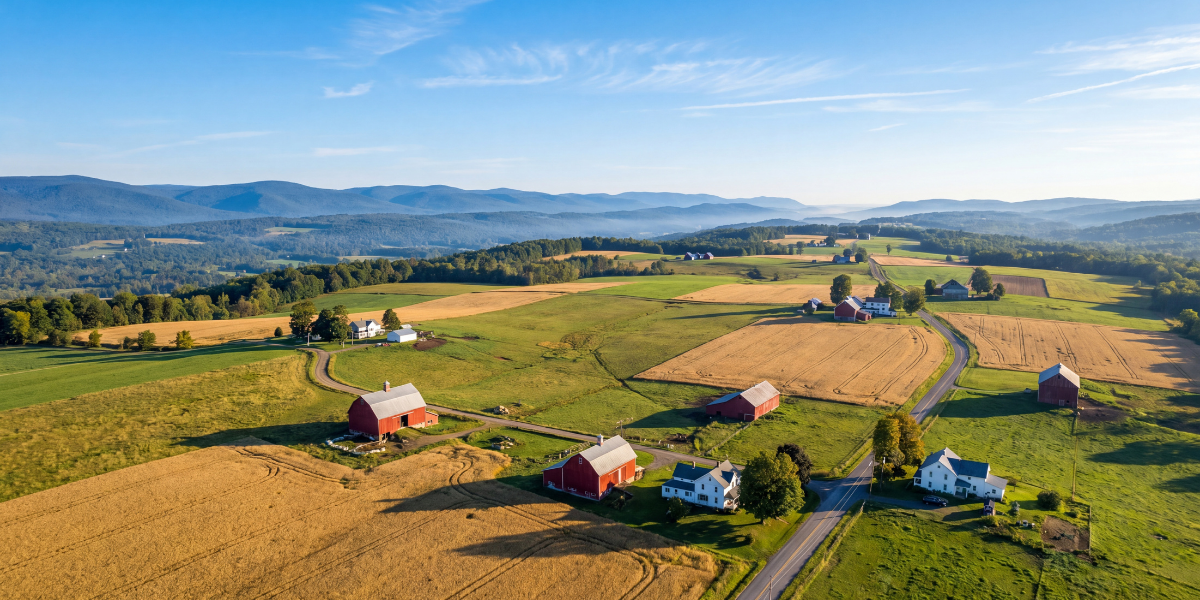 Aerial view of rolling Otsego County farmland in early autumn with Catskill foothills in the distance